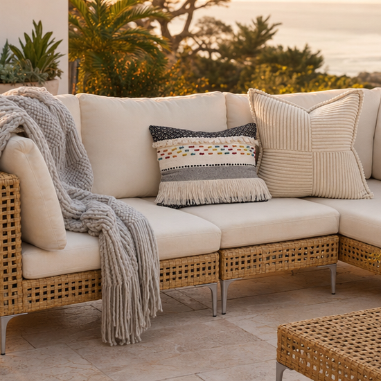 Dune chunky-knit throw styled on a coastal patio sofa at golden hour