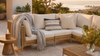Dune chunky-knit throw styled on a coastal patio sofa at golden hour